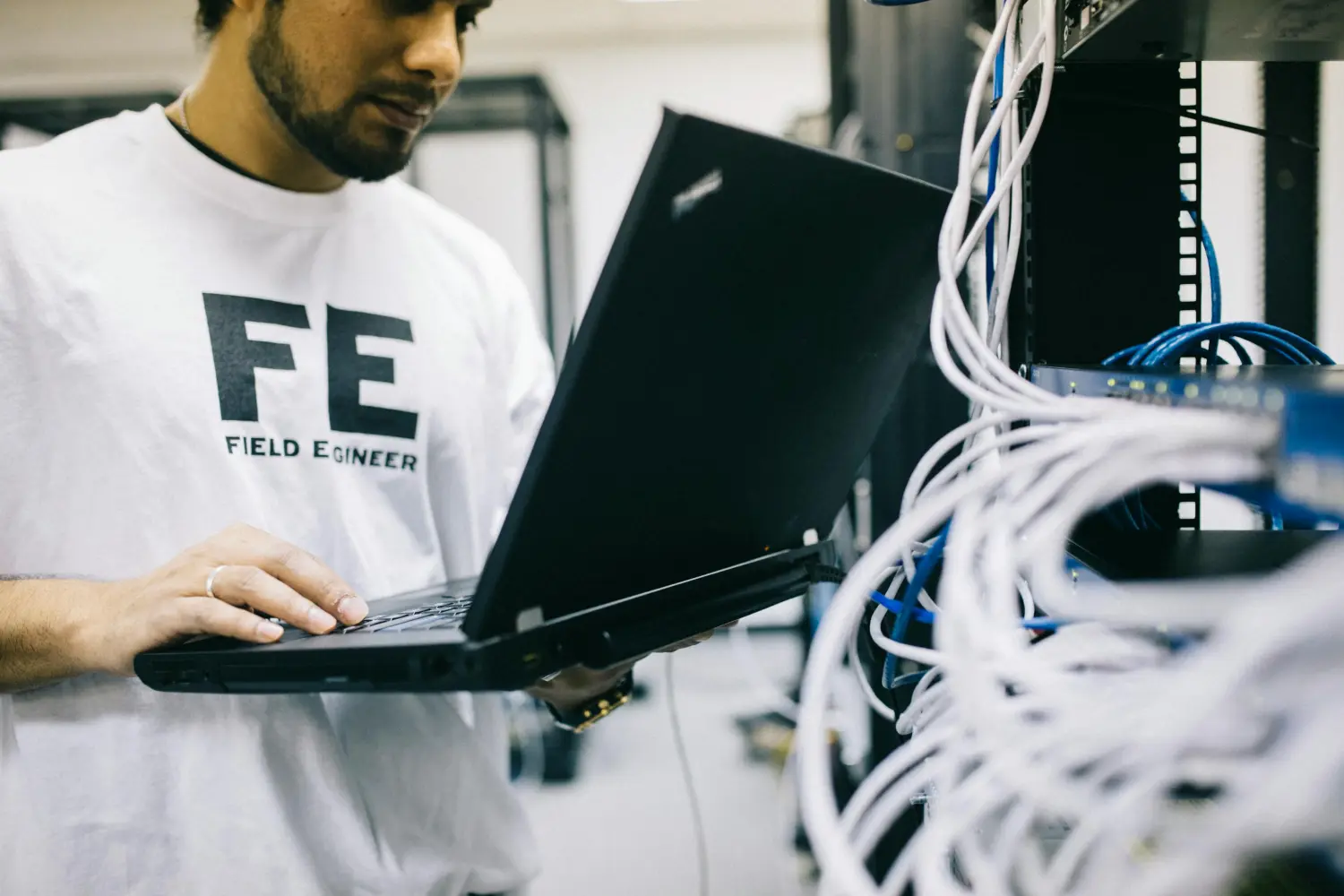 FST Gebäudedienstleistung - Mann benutzt Laptop zur Konfiguration der elektrischen Anlage