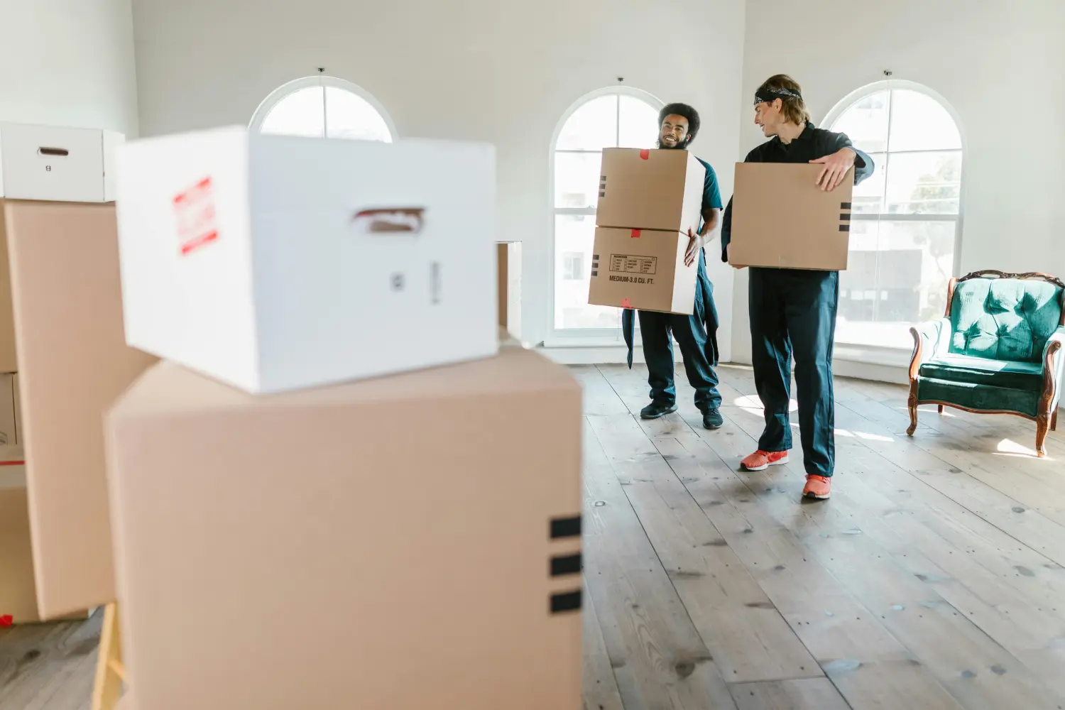 Umzugshelfer tragen die großen Kartons im Haus